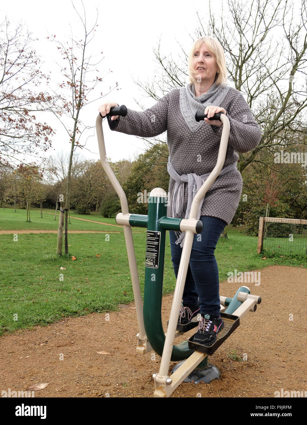 Reife Frau auf einem Heimtrainer in öffentlichen Parks, Swanley, Kent, Großbritannien. Stockfoto