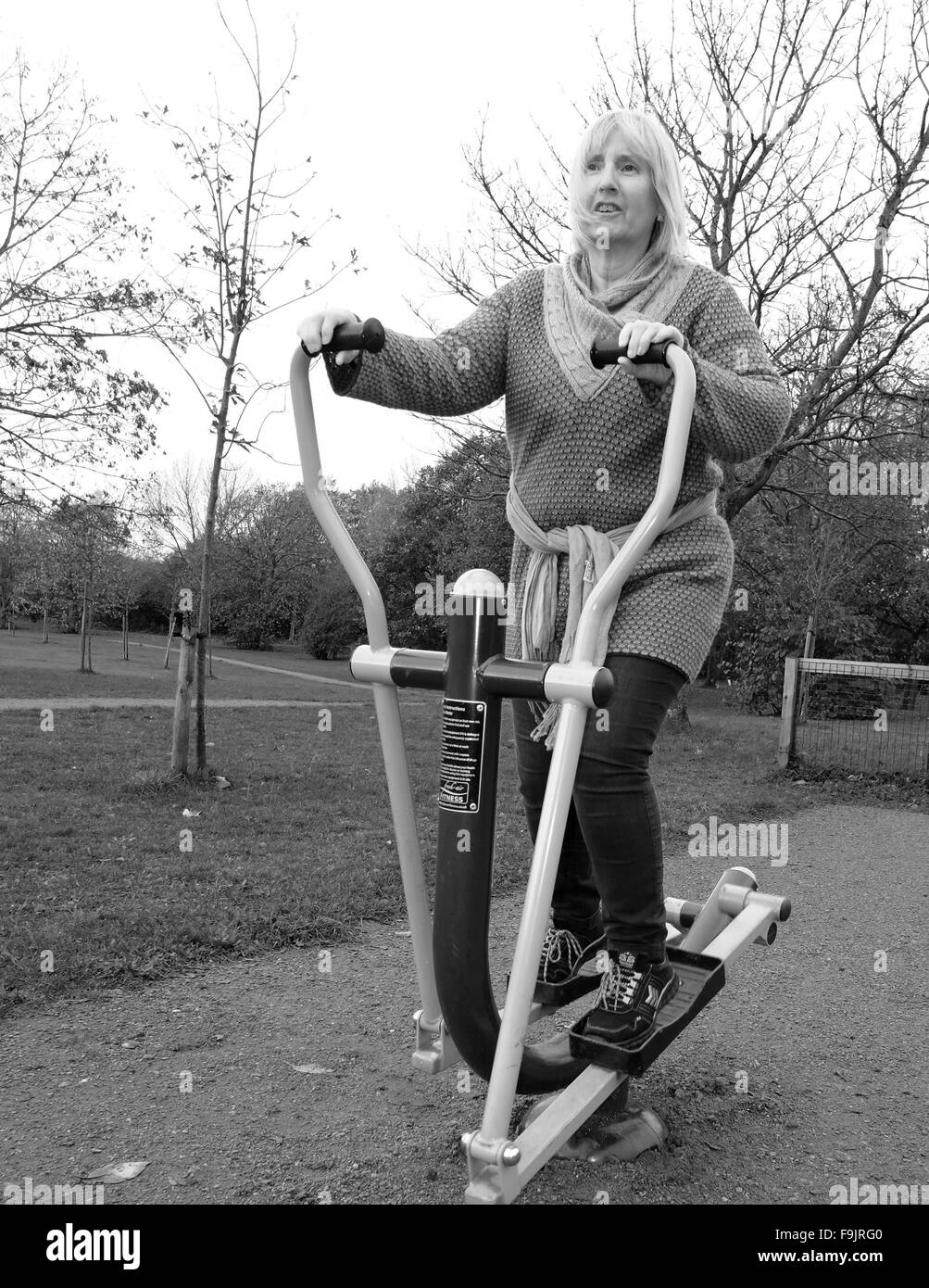 Reife Frau auf einem Heimtrainer in öffentlichen Parks, Swanley, Kent, Großbritannien. Stockfoto