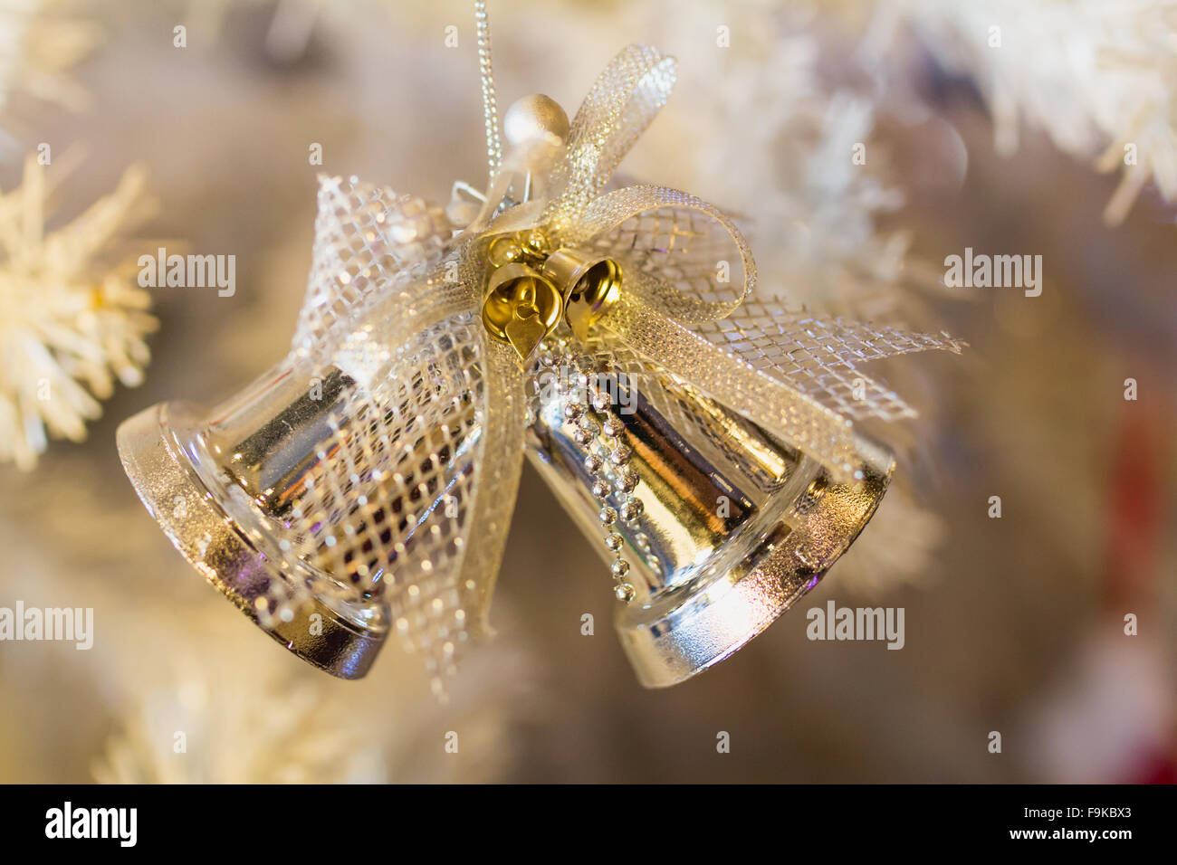 Goldene Glocke und weißen Weihnachtsbaum Hintergrund. Stockfoto
