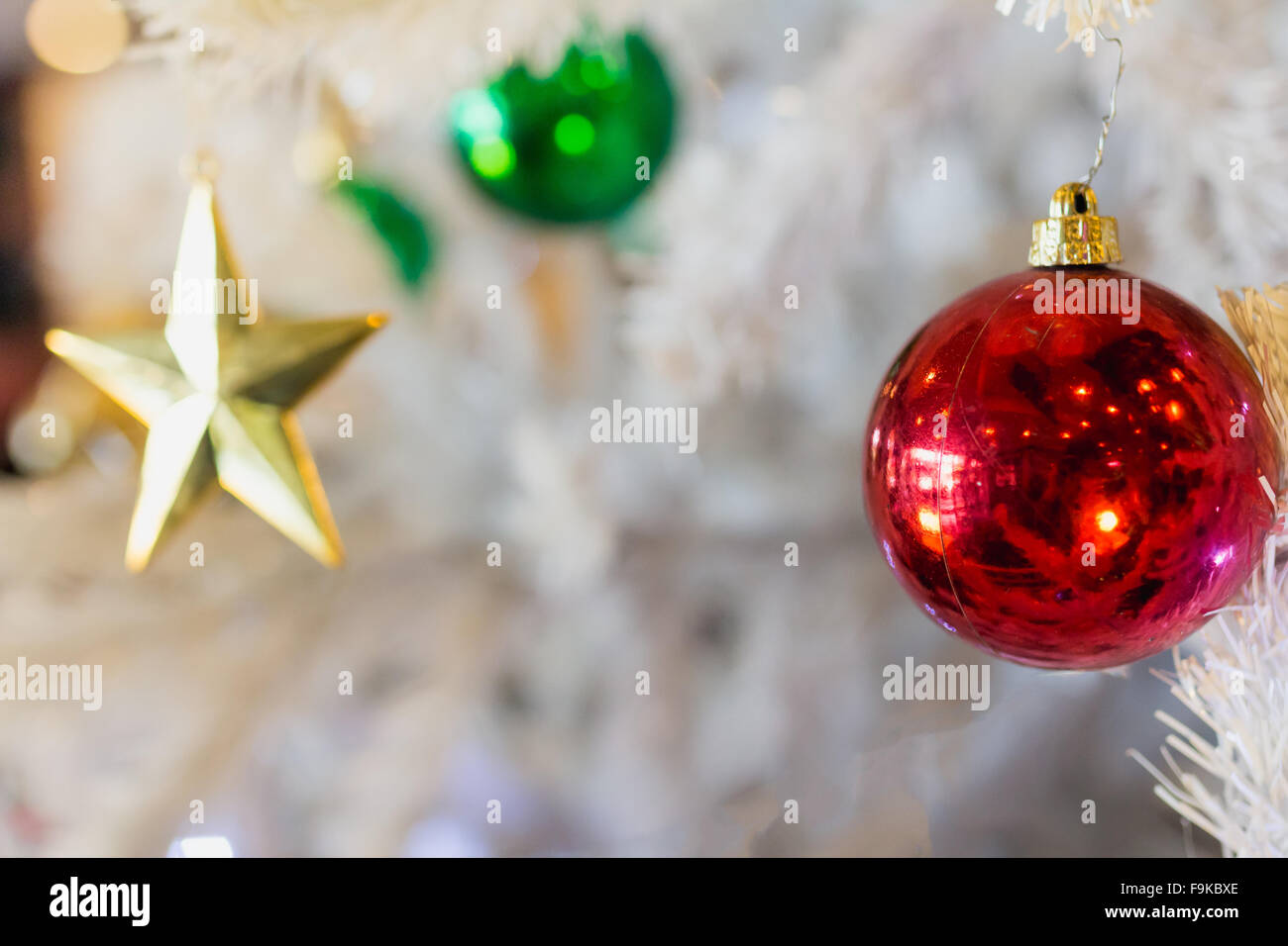 Goldener Stern rot grüne Kugel mit weißen Weihnachtsbaum Hintergrund. Stockfoto