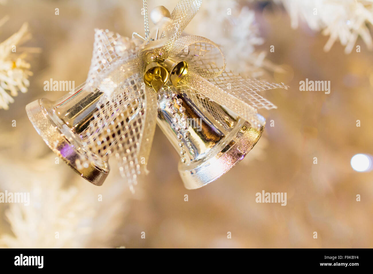 Goldene Glocke und weißen Weihnachtsbaum Hintergrund. Stockfoto