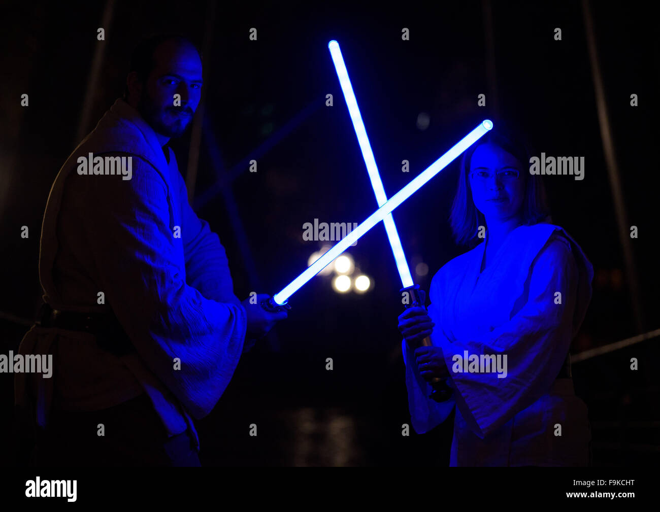 Nürnberg, Deutschland. 16. Dezember 2015. Sven aus Nürnberg und Ines aus Heidelberg stellen in Jedi Kostüme mit leichten Säbeln in einem Kino in Nürnberg, 16. Dezember 2015. Ab der Nacht vom 16. Dezember bis 17. Dezember 2015, Star Wars-Fans feiern die Eröffnung des neuen Star Wars Film "Star Wars: das Erwachen der macht. Foto: NICOLAS ARMER/Dpa/Alamy Live News Stockfoto