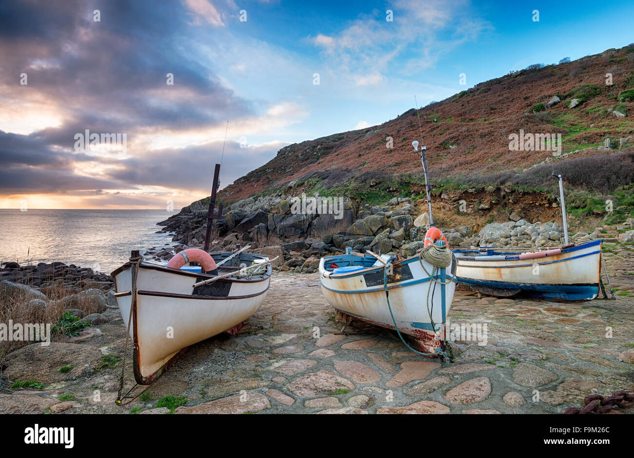 Dramatischer Himmel im Morgengrauen über Angelboote/Fischerboote am Penberth Cove im äußersten Westen von Cornwall Stockfoto