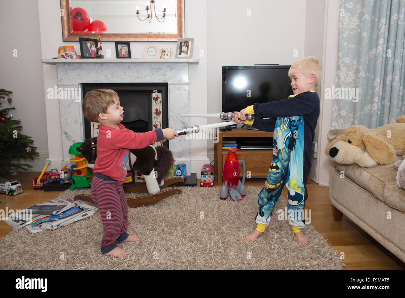 Zwei junge Brüder, Re-enacting einen Star Wars Lichtschwert Kampf zu Hause in ihrem Wohnzimmer, UK Stockfoto
