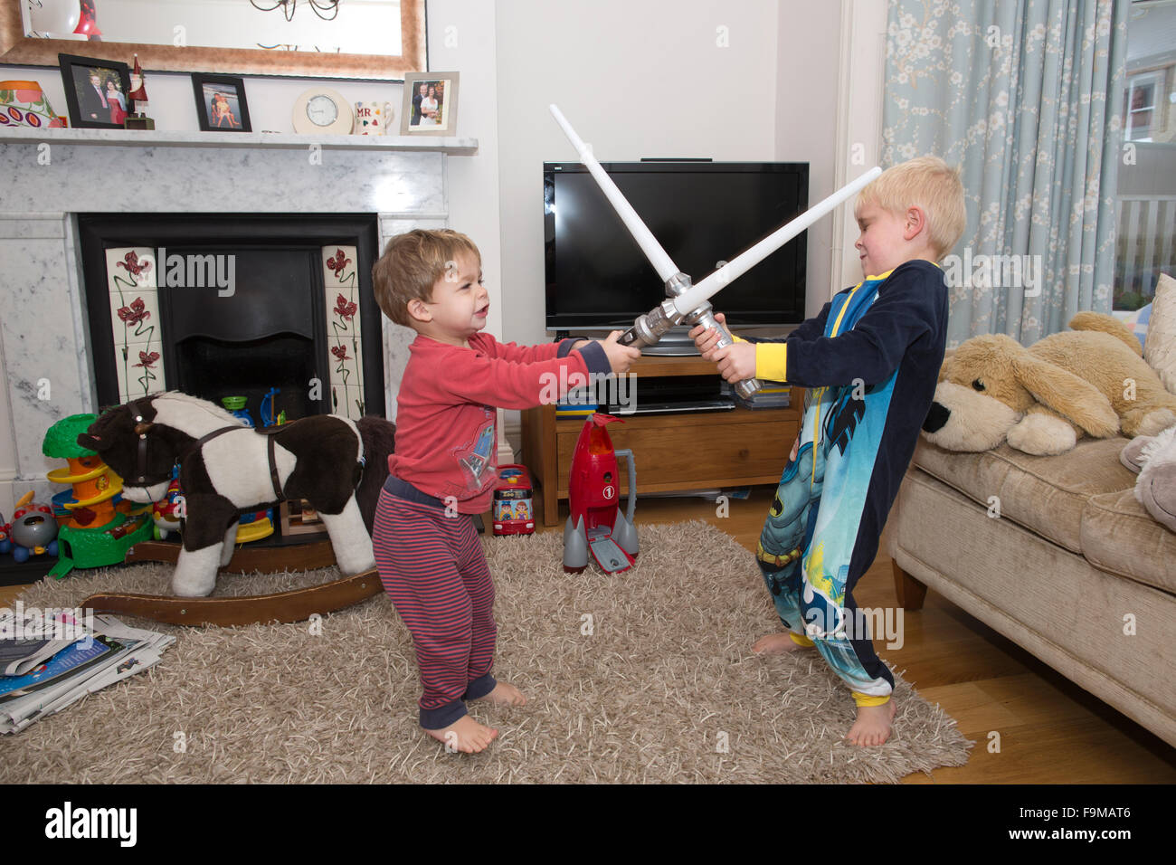 Zwei junge Brüder, Re-enacting einen Star Wars Lichtschwert Kampf zu Hause in ihrem Wohnzimmer, UK Stockfoto