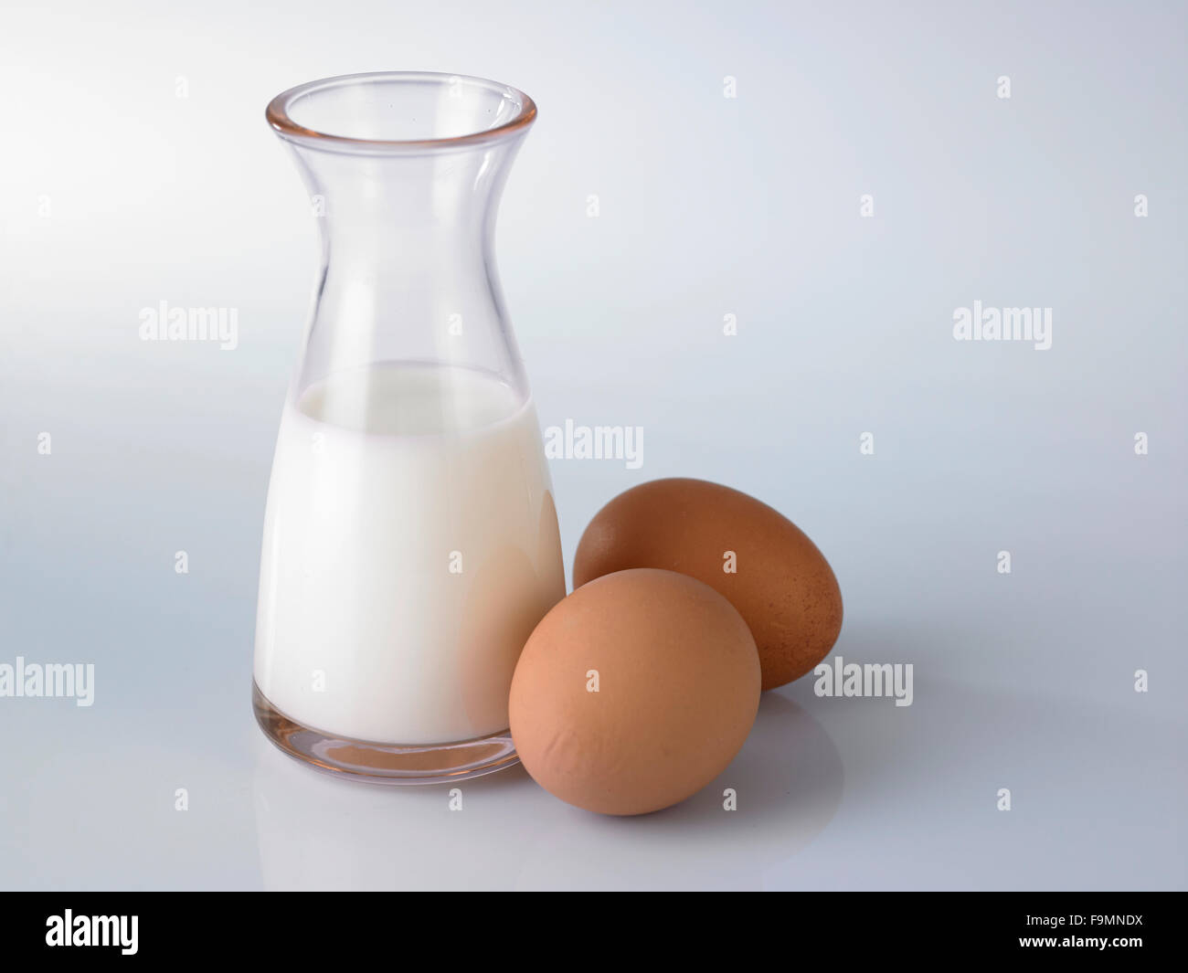 Milch und Eiern auf weißem Hintergrund. Stockfoto