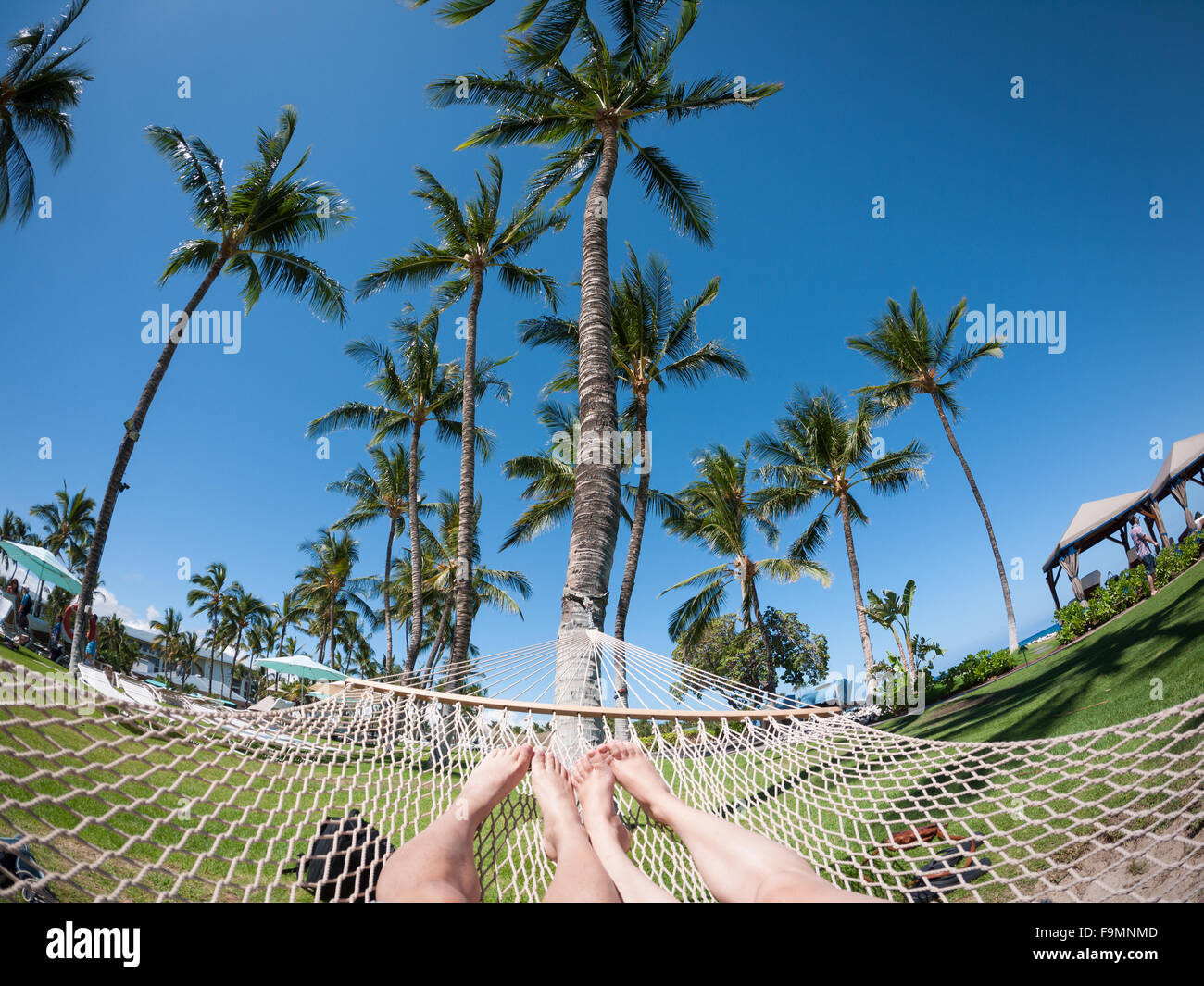 Einen weiten Winkel fisheye Blick auf ein junges Paar Füße in einer Hängematte auf dem Gelände der Fairmont Orchid, Kohala Coast, Hawai ' i. Stockfoto
