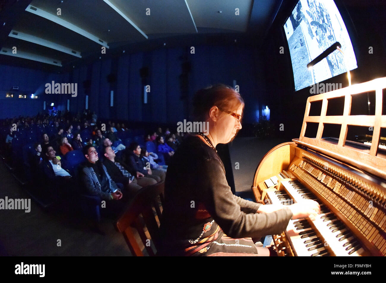 Potsdam, Deutschland. 17. Dezember 2015. Susanne Schark spielen auf einem historischen Kinoorgel aus den 1920er Jahren in Potsdam, Deutschland, 17. Dezember 2015. Das Filmmuseum Potsdam eingeladen Flüchtlinge zu einer Veranstaltung mit dem Titel "Flüchtlinge aufzunehmen - Stummfilm-Abenteuer Mit Livemusik" (lit.) Flüchtlinge willkommen - Abenteuer Stummfilm mit live-Musik). Foto: BERND SETTNIK/ZB/Dpa/Alamy Live News Stockfoto