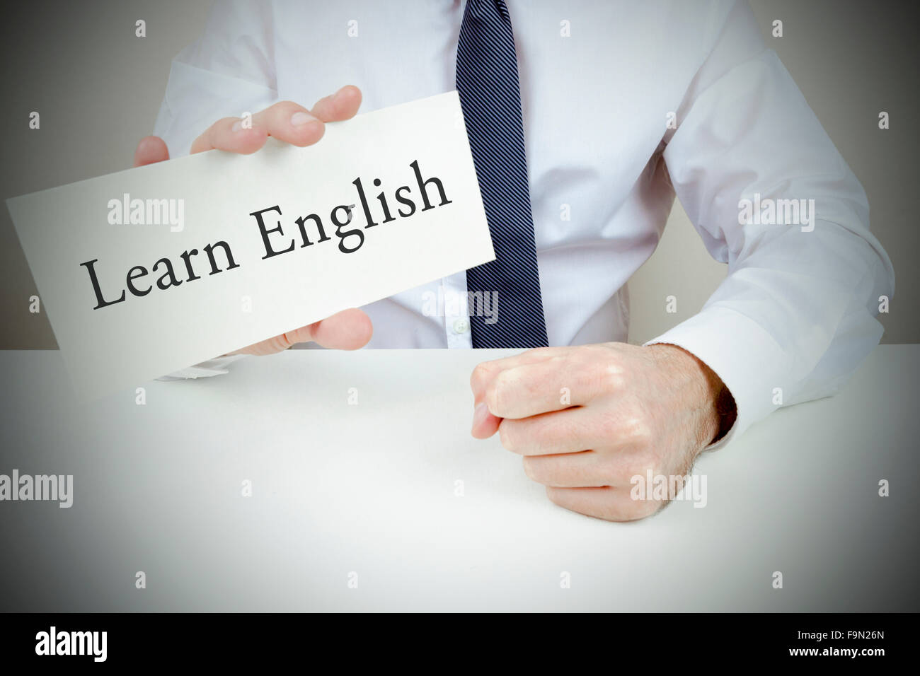 Ein Mann gekleidet in Hemd und Krawatte hält eine Karte, um Englisch zu  lernen Stockfotografie - Alamy