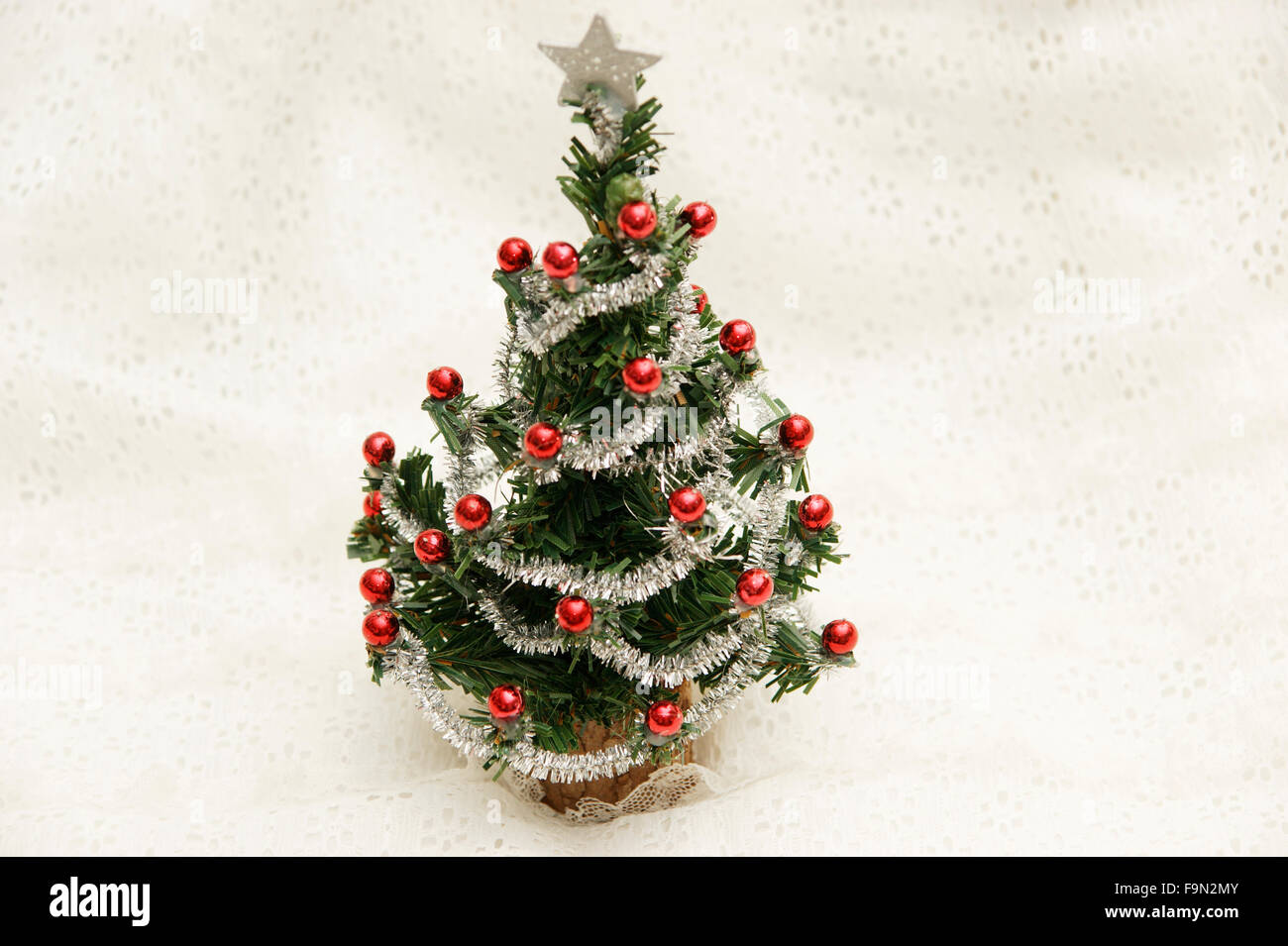 Miniatur-Weihnachtsbaum mit einem Stern auf einem Hintergrund zeigt eine Schneelandschaft Stockfoto