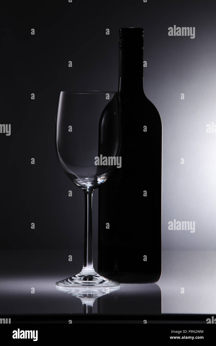 Glas Wein und eine Flasche in schwarzem Hintergrund Stockfoto