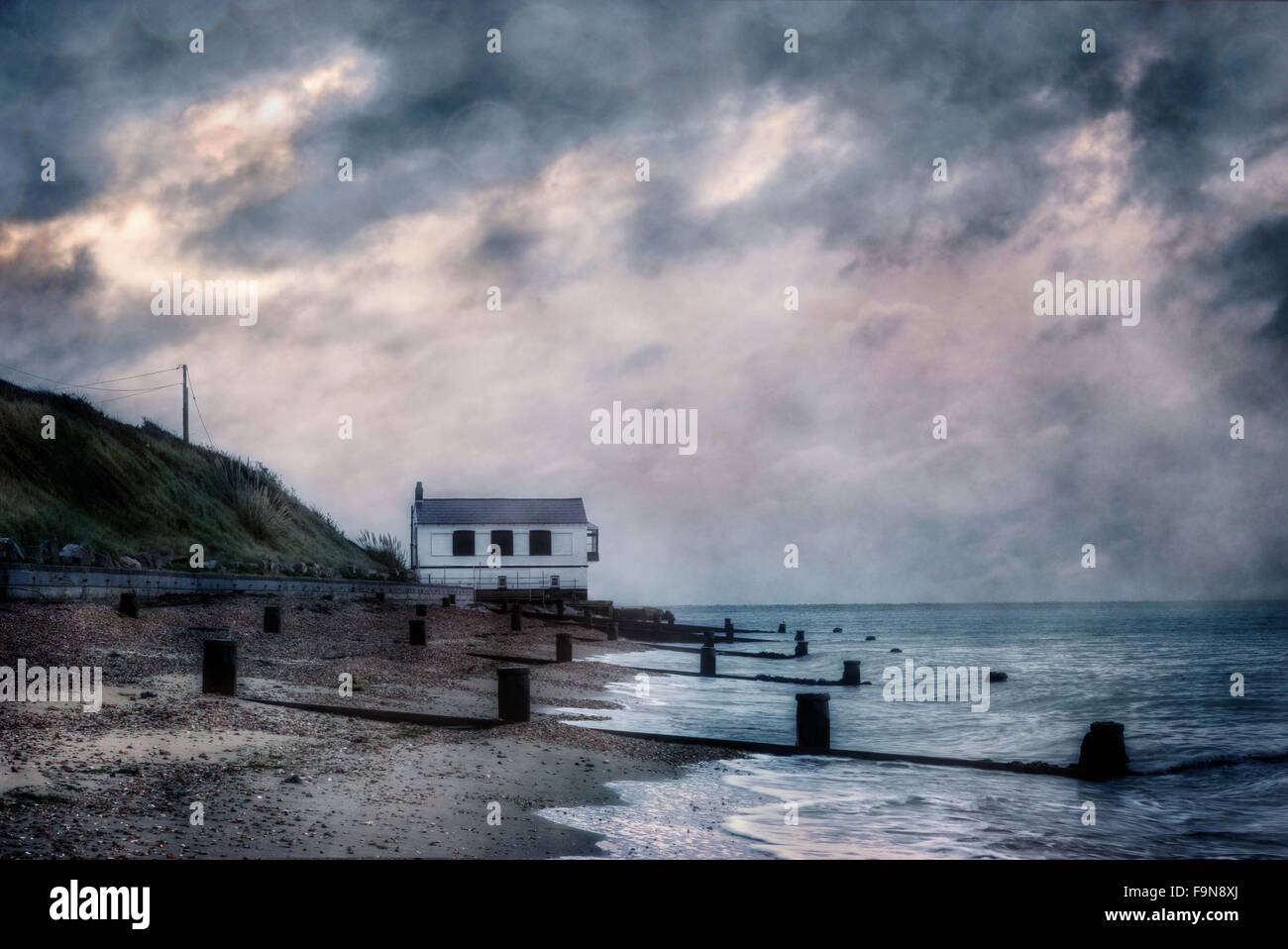 ein Ferienhaus am Meer unter Gewitterhimmel Stockfoto