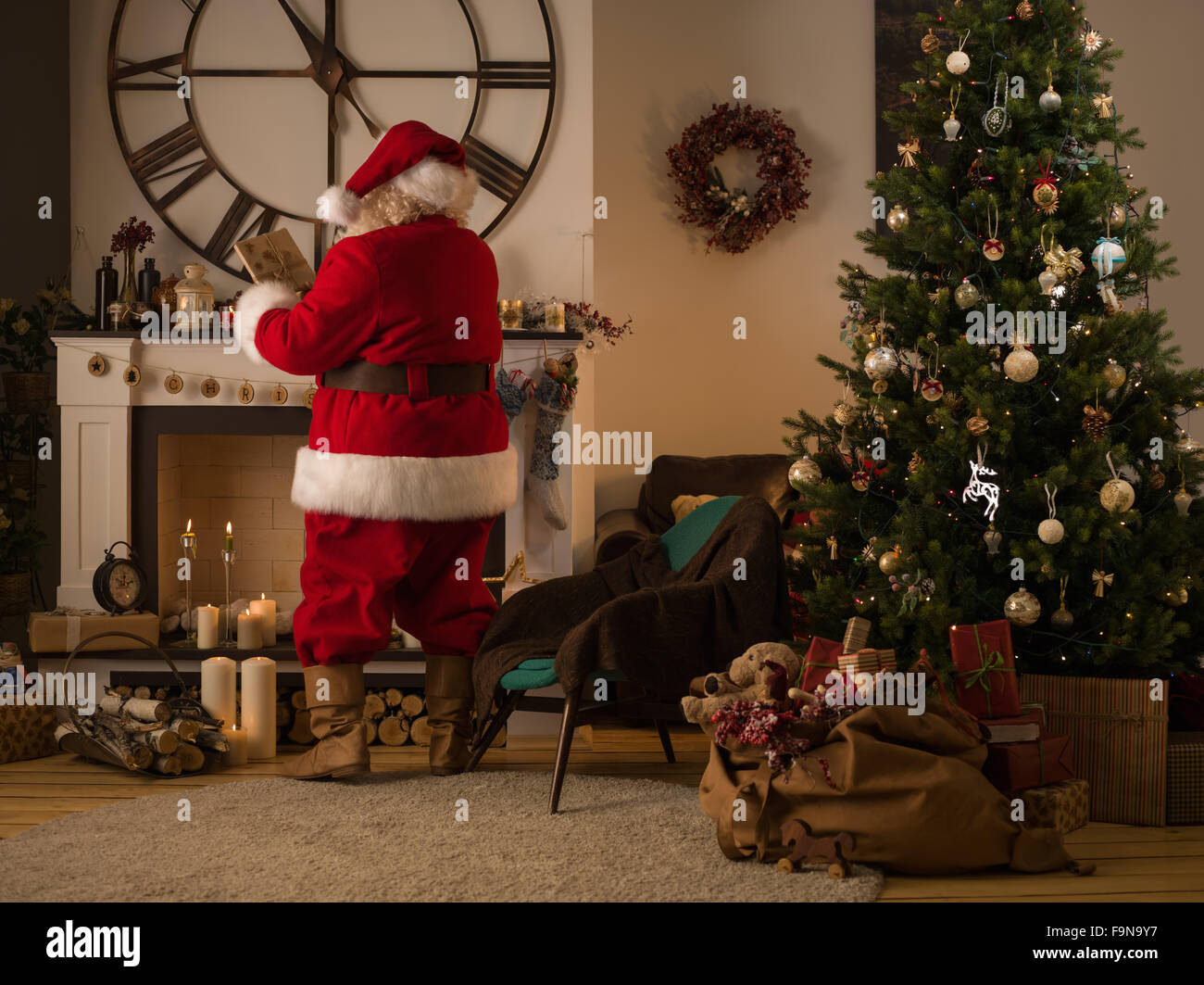 Weihnachtsmann, Geschenke in Socken auf Kamin zu Hause Stockfoto