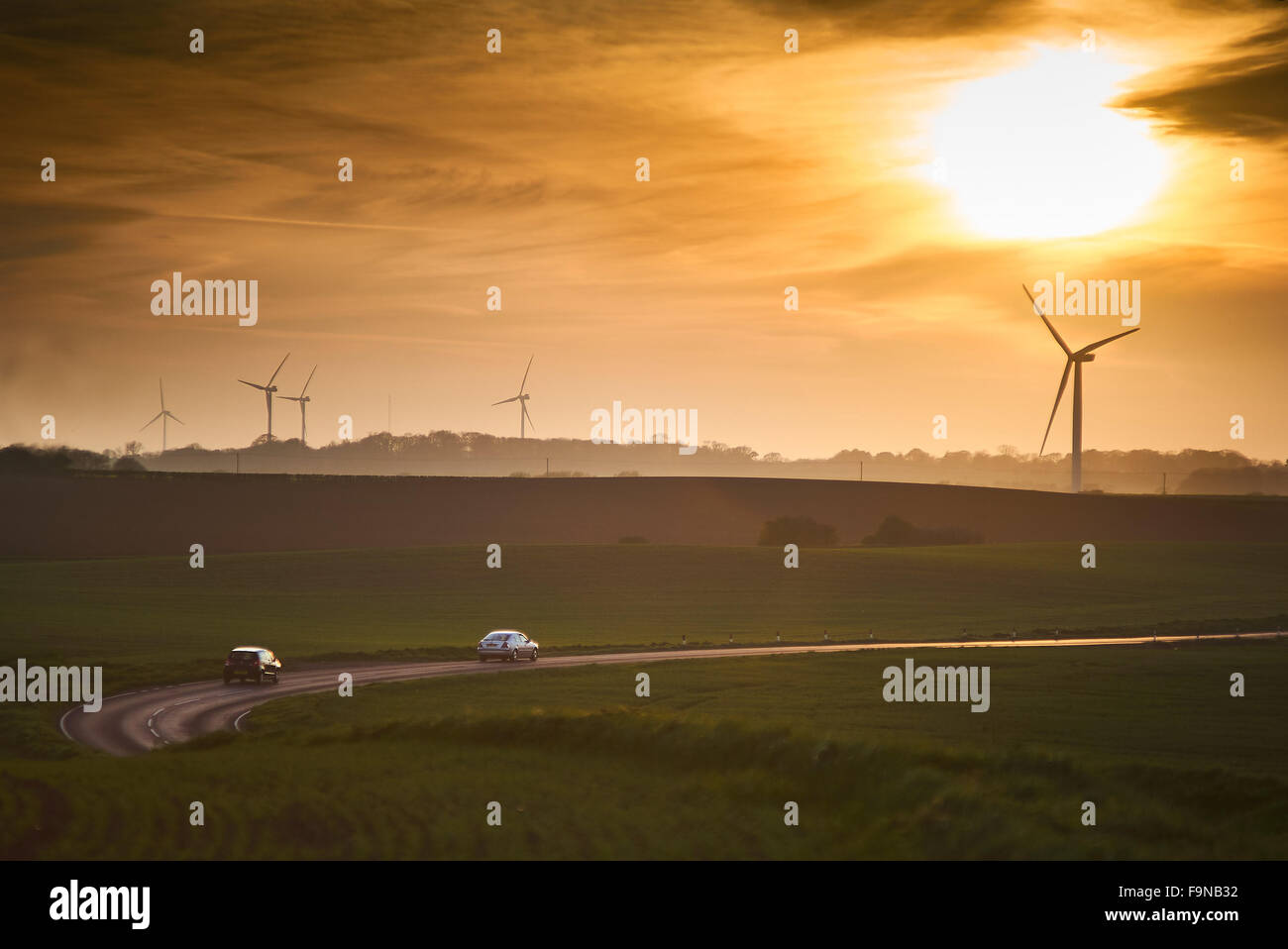 Windkraftanlagen im Windpark auf Ackerland in Yorkshire während einer Sommer-Sonnenuntergang Stockfoto