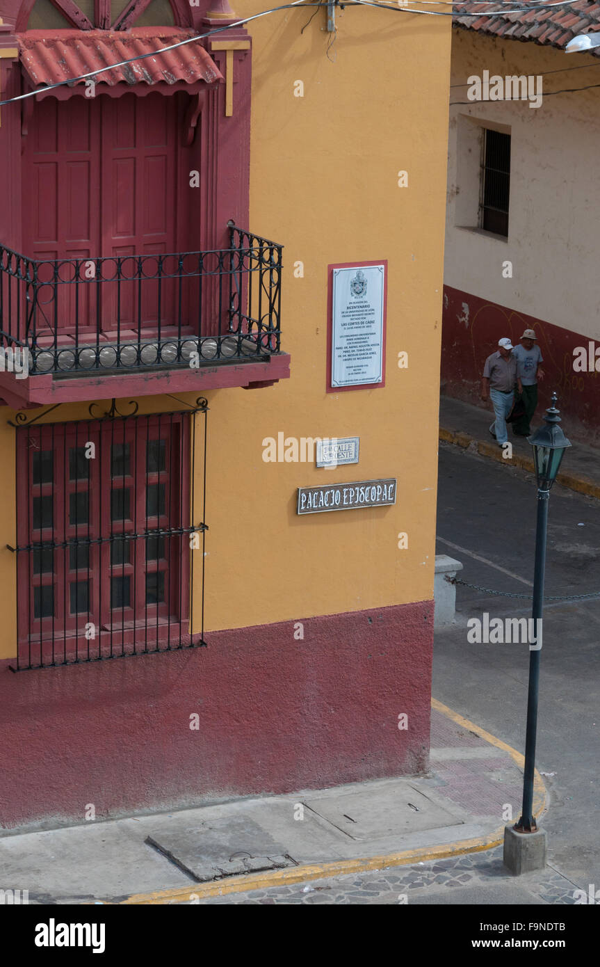 Passanten auf der Straße neben einem roten gelben Haus im Kolonialstil und Ecke in Leon Stockfoto