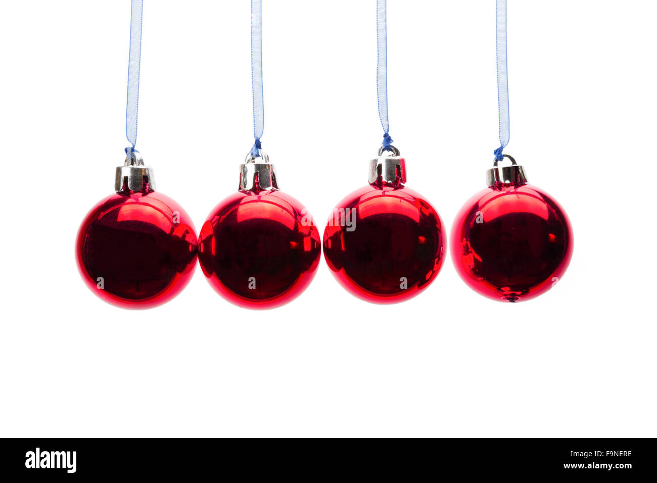 Vier rote Weihnachtskugeln hängen in einer horizontalen Zeile isoliert auf weißem Hintergrund Stockfoto