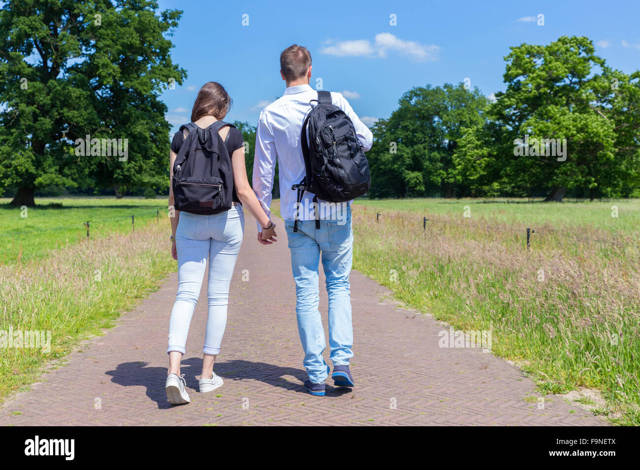 Junger Mann und Frau gehen zusammen auf der Straße in der Natur an sonnigen Tag Stockfoto