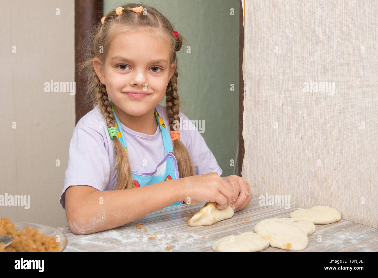 Vierjährige Mädchen bereitet Torten mit Kraut in der Küche Stockfoto