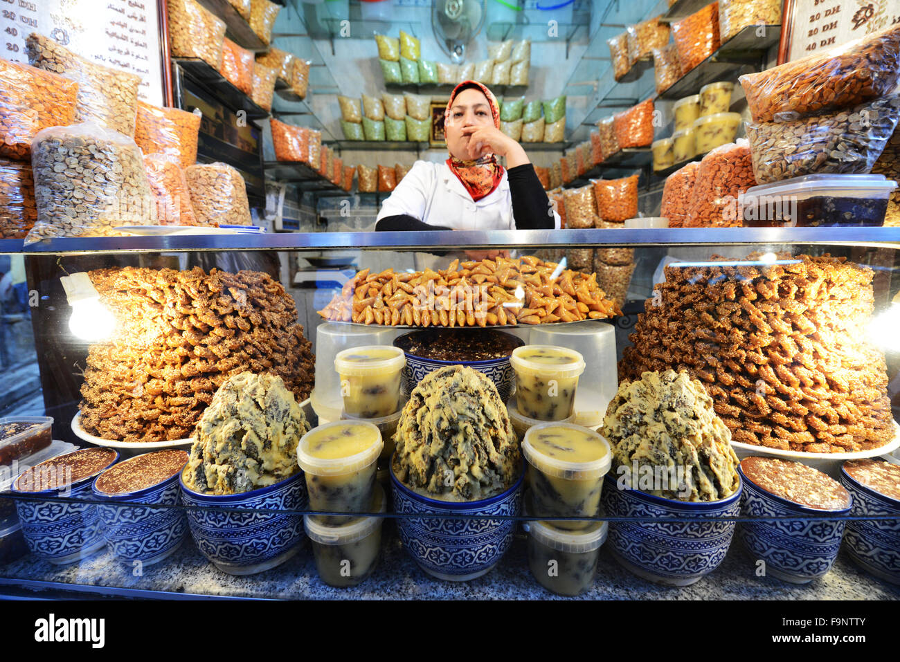 Ein kleines Geschäft in der Altstadt von Fes. Auf dem Display einige frittierte Snacks, Süßigkeiten und Kamel Schmalz die Chelir genannt wird. Stockfoto
