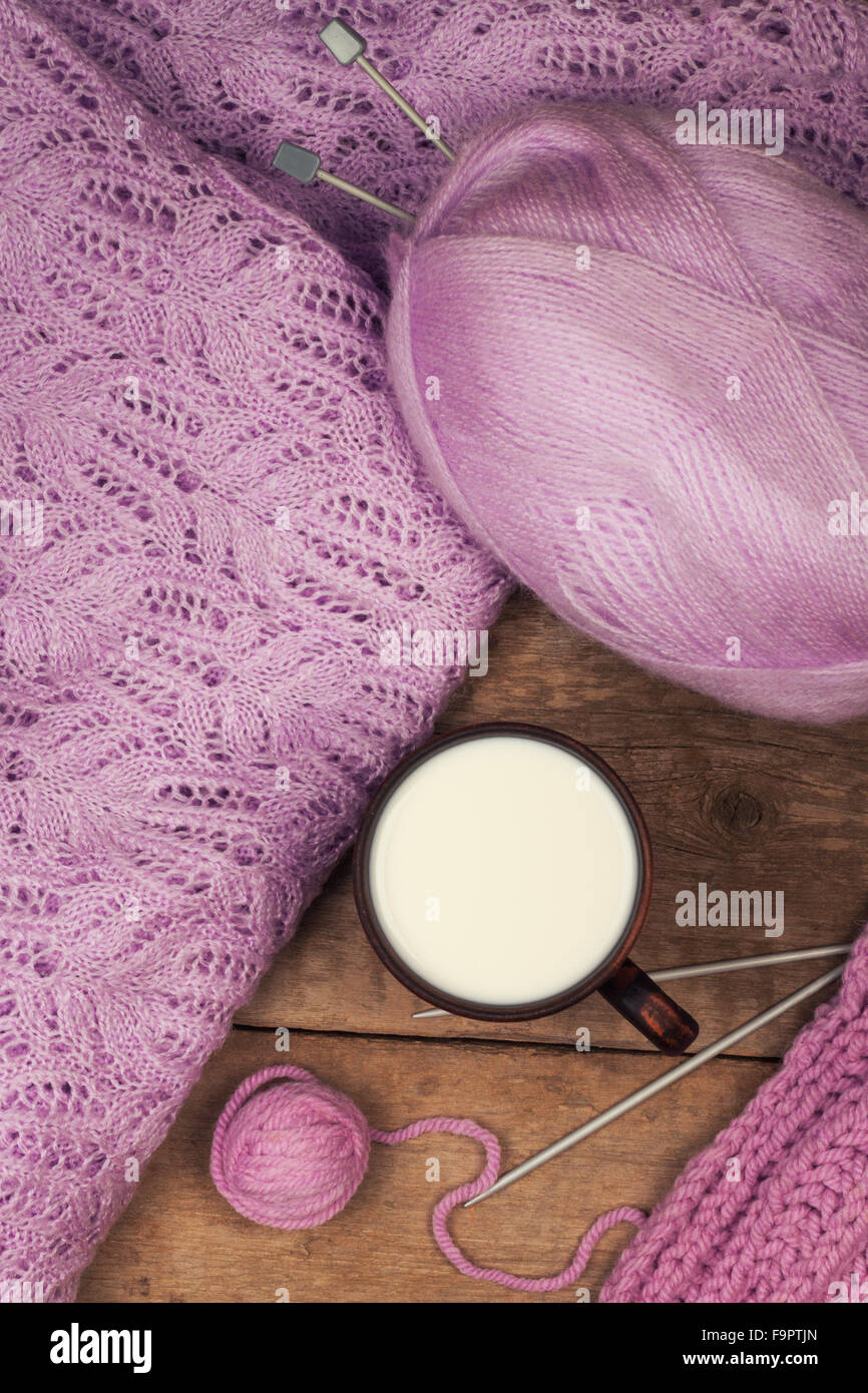 lila Pullover mit einer Ton-Tasse warme Milch auf dem Holztisch Stockfoto