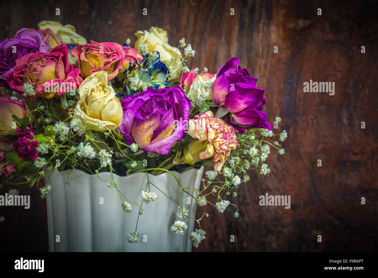 Vintage bunte Rosen auf dunklen Ton aus Holz Hintergrund erhalten Stockfoto