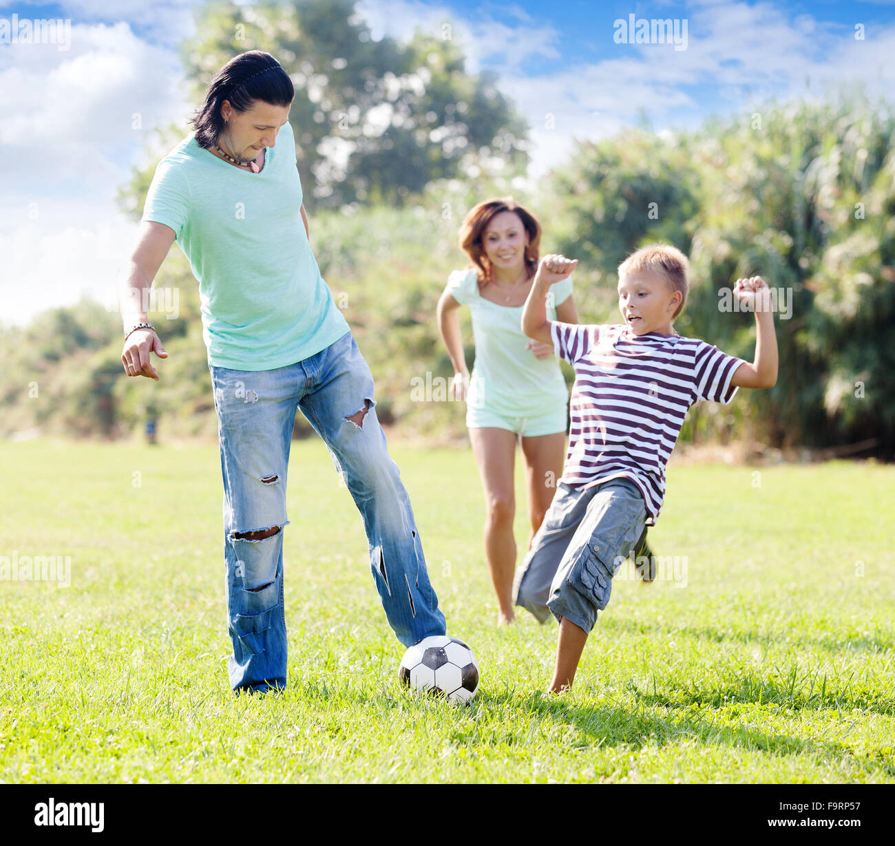Familie mit Teenager Kind spielen mit Fußball im Sommerpark Stockfoto