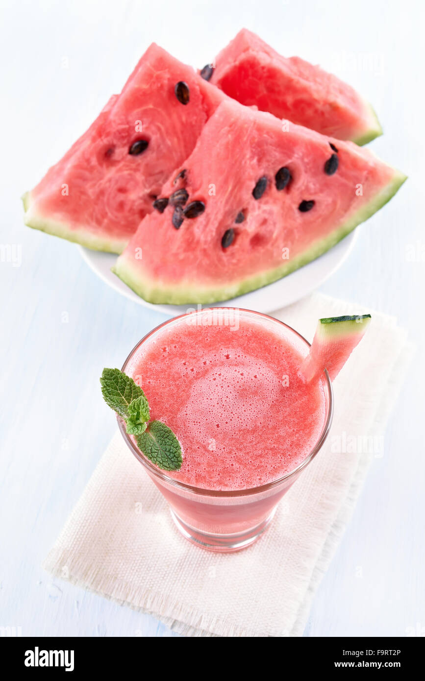 Wassermelonensaft in ein Glas und in Scheiben schneiden Stockfoto