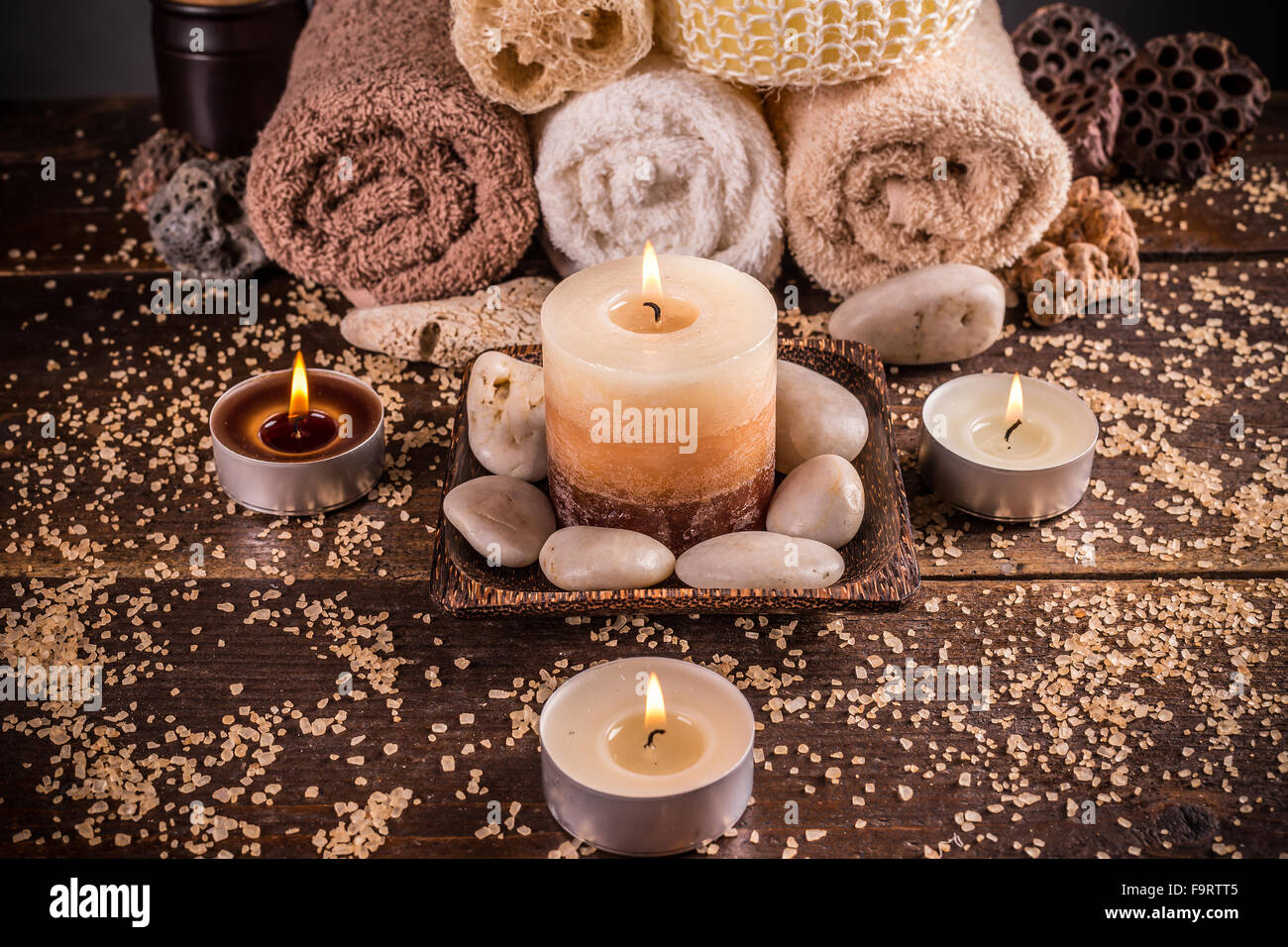 Spa-Einstellung mit Handtüchern und Kerzen Stockfoto