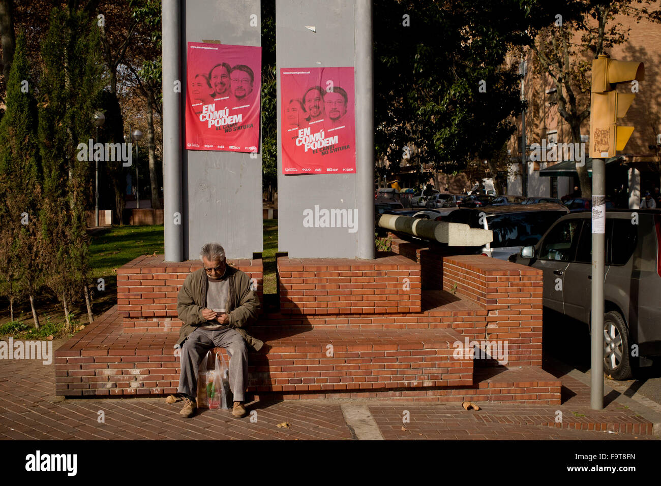 Barcelona, Katalonien, Spanien. 18. Dezember 2015. Ein älterer Mann ist in der Nähe von Plakaten katalanische Partei En Comu Podem mit den Gesichtern von Pablo Iglesias und Barcelona Bürgermeister Ada Colau drauf an El Besos Viertel von Barcelona am 18. Dezember 2015 gesehen. El Besos Stadtteil in Barcelona hat eine der am stärksten betroffen von der Finanzkrise der letzten Jahre, die Arbeitslosenquote steigt auf 22 Prozent und hat einen der das niedrigste pro-Kopf-Einkommen der Stadt. Die politische Partei gewann Barcelona En Comu, unter der Leitung von Bürgermeister Ada Colau, die letzten Kommunalwahlen in diesem Bezirk. Stockfoto