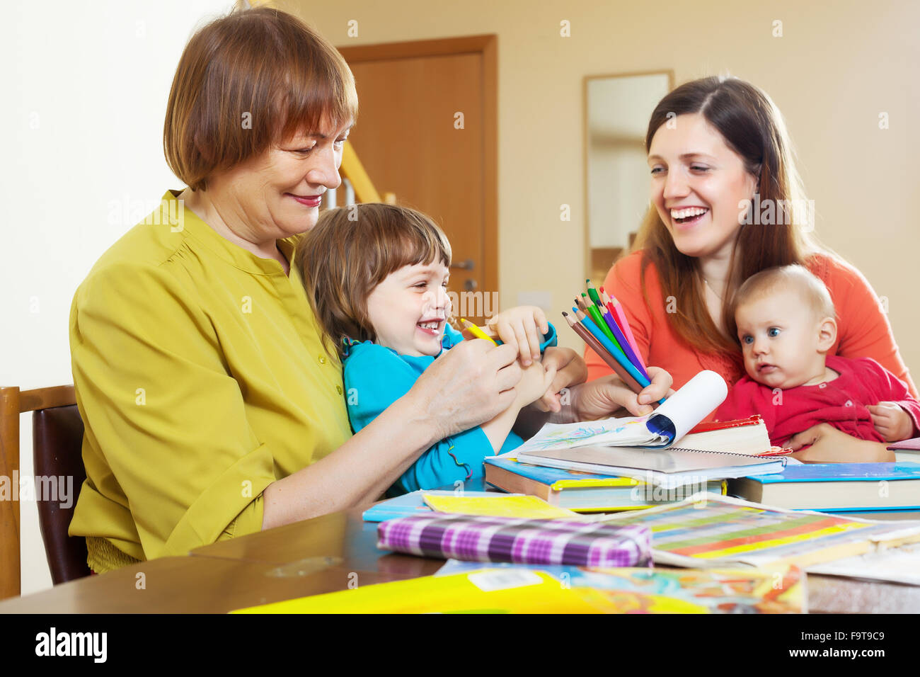Glücklich Reife Frau mit Tochter und Enkel am Tisch spielen Stockfoto