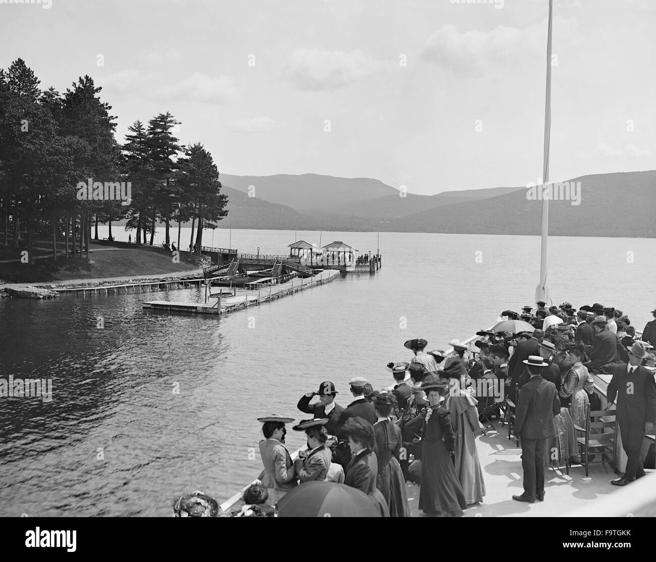 Gruppe von Menschen auf Boot nähert sich Sagamore Dock, Green Island, Lake George, New York, USA, ca. 1904 Stockfoto