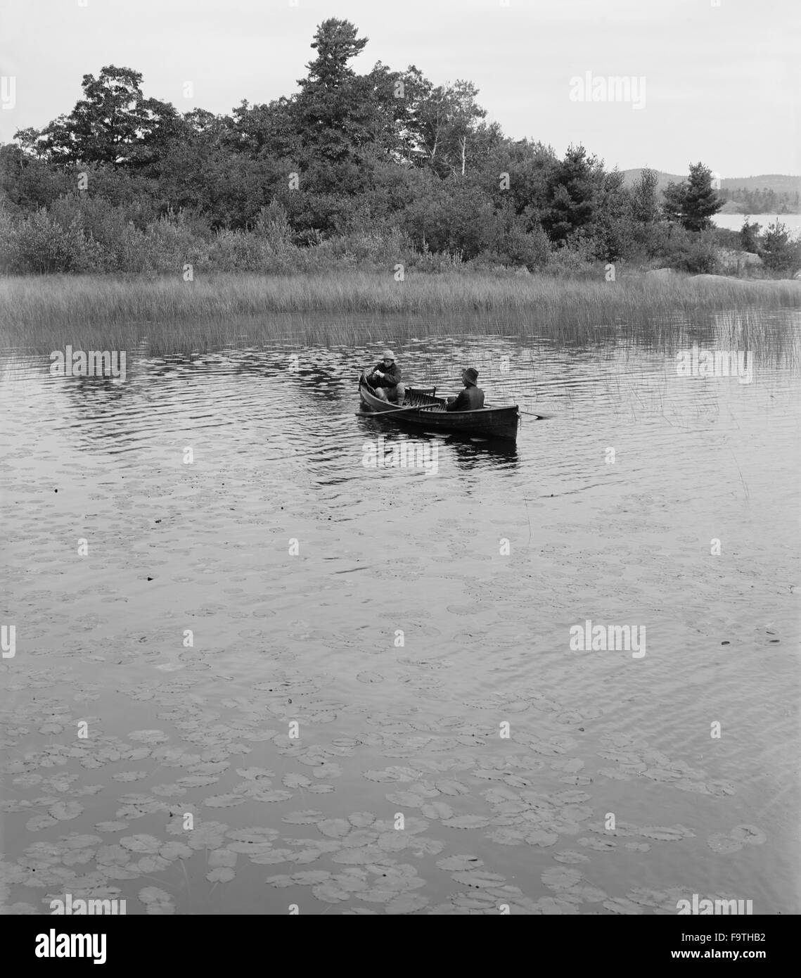 Zwei Männer im Kanu unter den Seerosen, Whitefish Bay, Ontario, Kanada, ca. 1905 Stockfoto