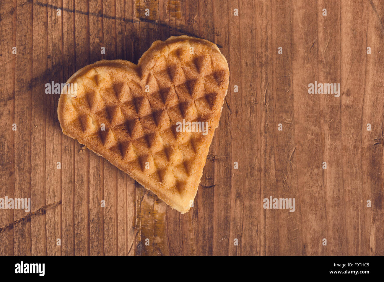 Herzförmige hausgemachte Waffel auf hölzernen Schreibtisch, Retro-getönten, Top Aussicht. Stockfoto