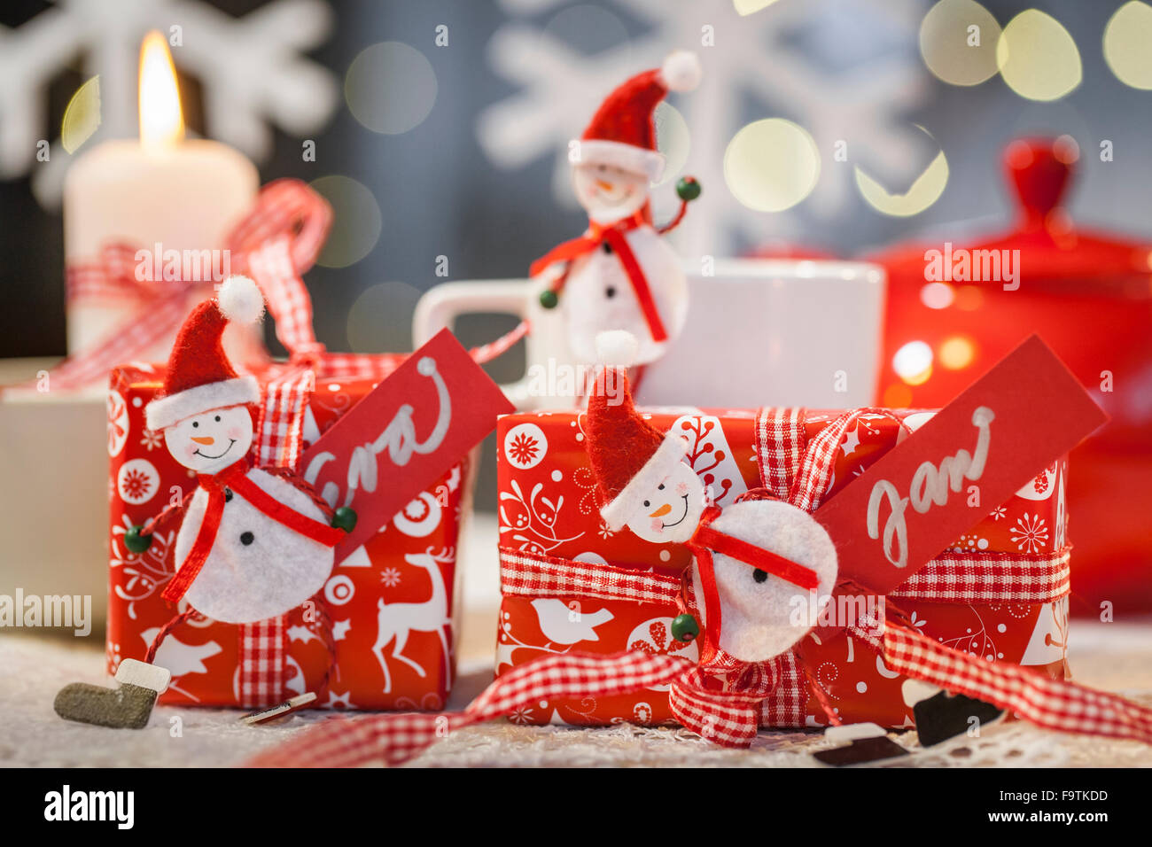 Material: rote Geschenkpapier mit einem Weihnachts-Motiv, rot-weiße Band  aus Filz Puppen, Wäscheklammern, Papier, rot, weiße Markierung, Schere.  Vorgehensweise: eine Puppe aus Filz auf den Zapfen kleben, Geschenke in  Packpapier und Bandage Bogen