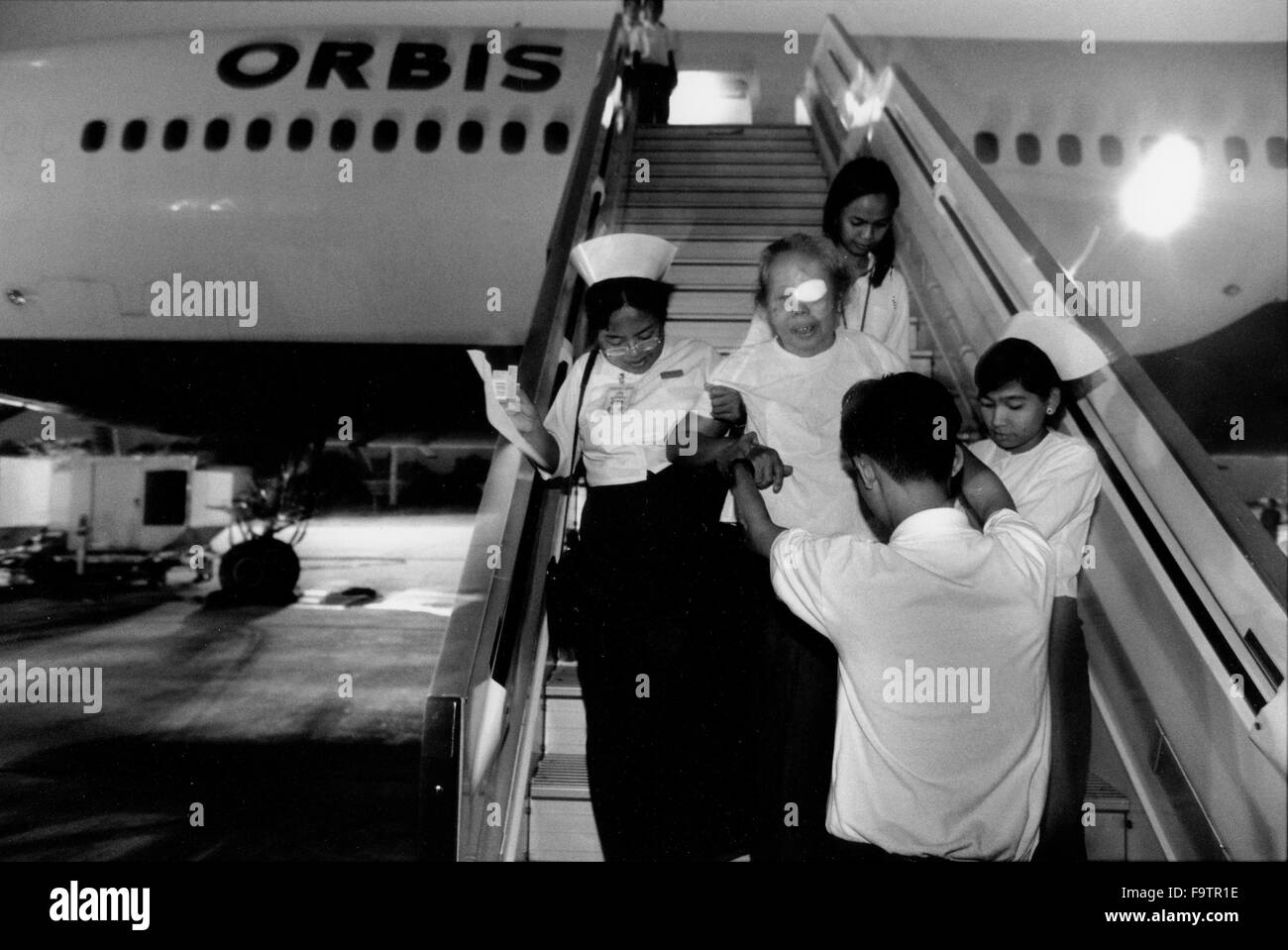 Orbis fliegende Augenklinik auf eine DC10 auf der Start-und Landebahn am Flughafen von Yangon, Myanmar. Patienten aus dem Flugzeug von Krankenschwestern nach erfolgreicher Operation geholfen. Stockfoto