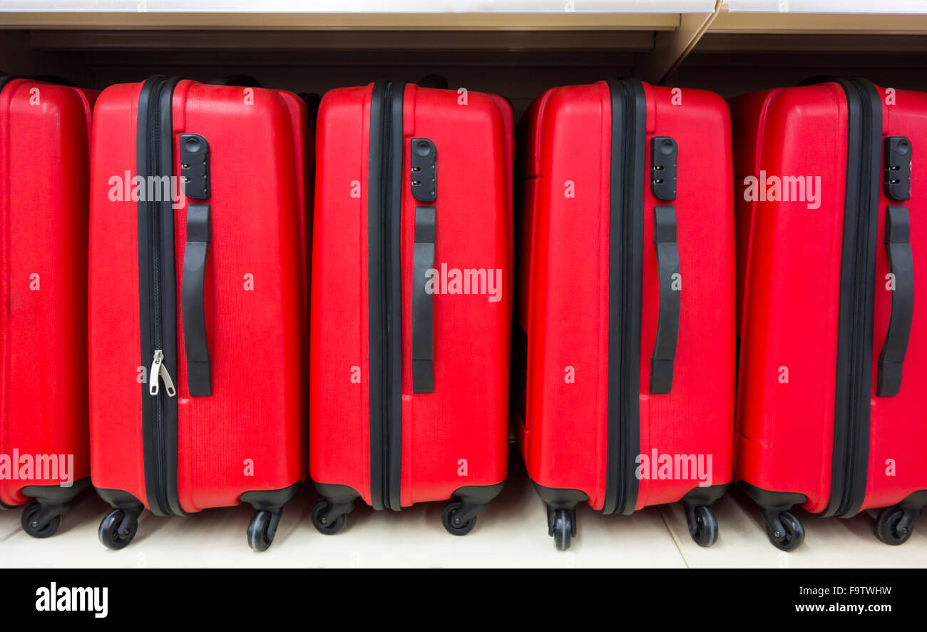 Roten Koffer in einer Reihe auf Regal Stockfoto