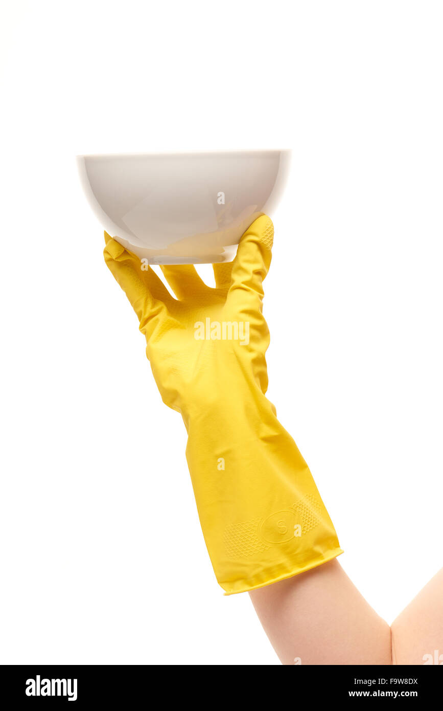 Nahaufnahme von weiblicher Hand in gelben schützende Gummihandschuh mit sauberen weißen Schüssel vor weißem Hintergrund Stockfoto