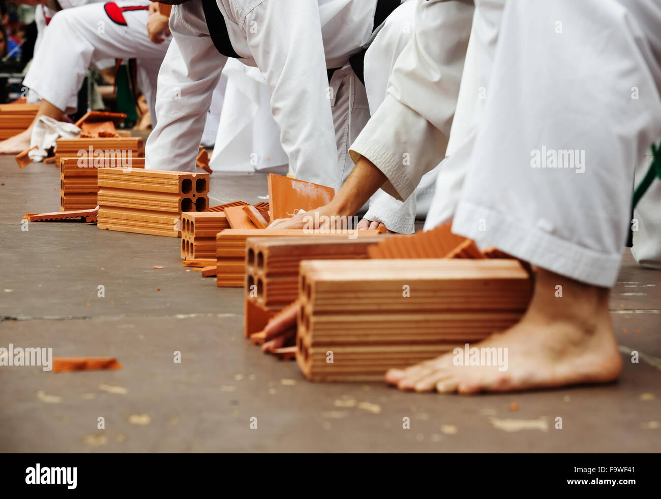 Karate Schüler zeigen ihr können durch das brechen von Steinen Stockfoto