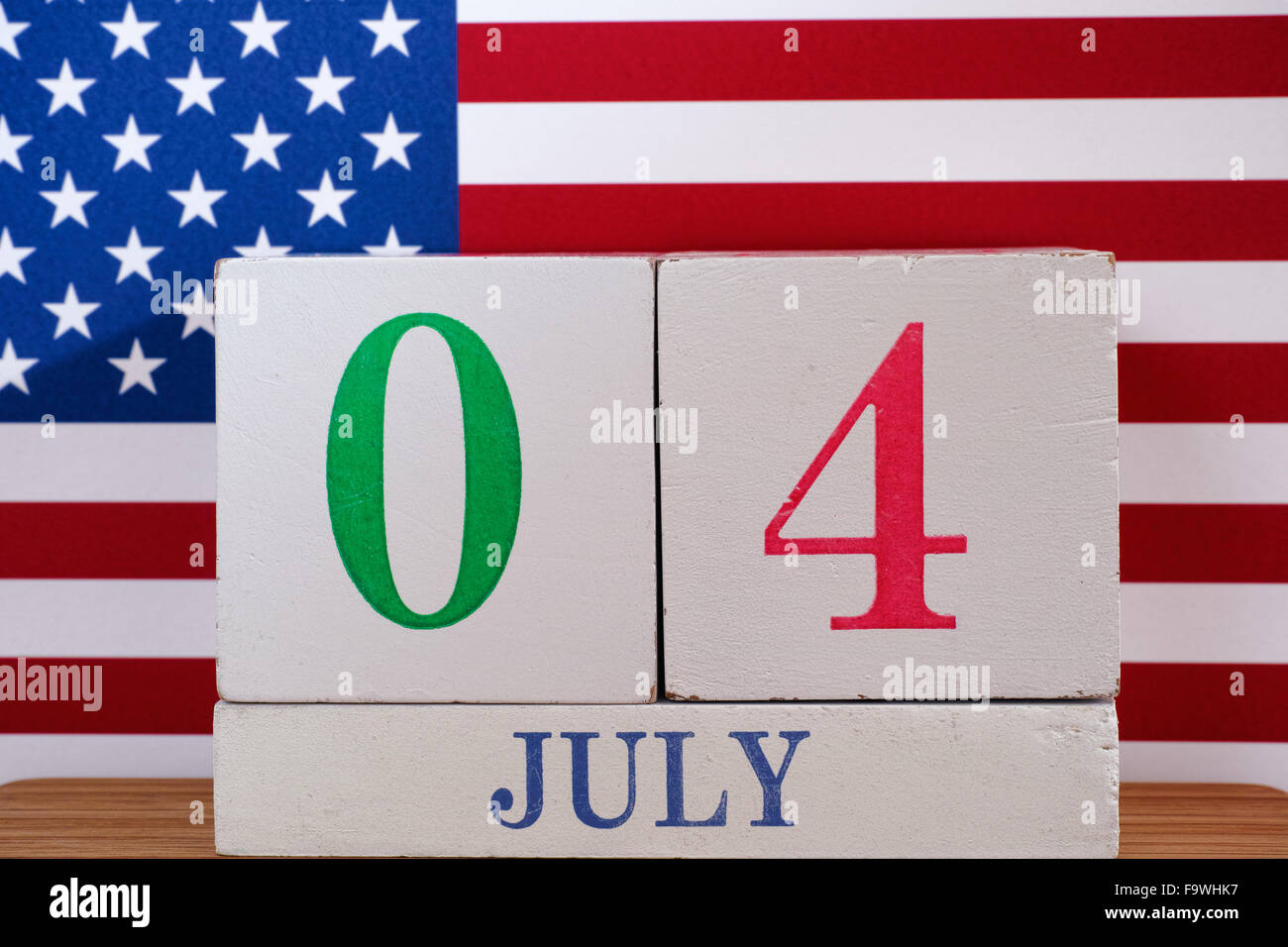 4. Juli - Tag der Unabhängigkeit. Hölzerne Kalender und amerikanische Flagge. Stockfoto