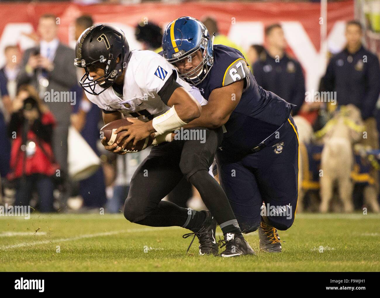 Navy Midshipmen Jarvis Polu (67) packt Army Black Knights quarterback Chris Carter während der NCAA Football-Spiel zwischen der Army Black Knights und die Navy Midshipmen spielten im Lincoln Financial Field 12. Dezember 2015 in Philadelphia, PA. Stockfoto