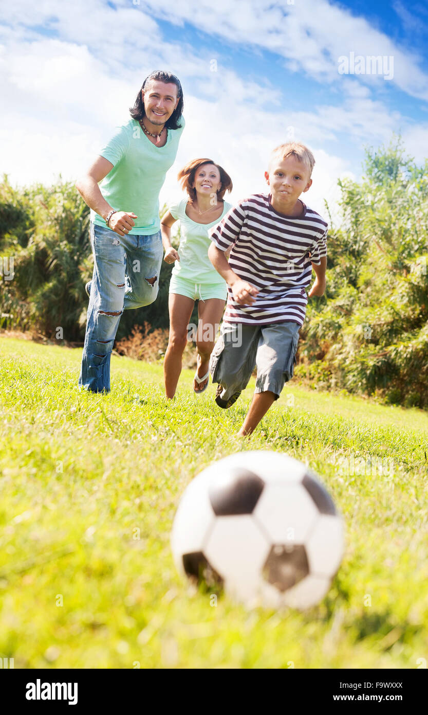 Brautpaar Erwachsene und Teenager spielen mit Fußball im Sommerpark Stockfoto