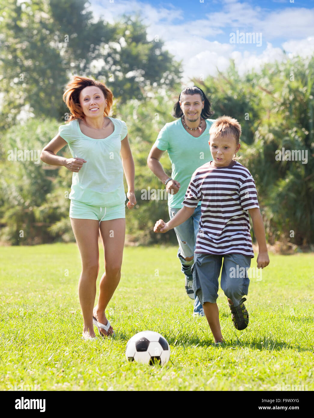 Familie von drei spielen im Fußball mit Ball im park Stockfoto