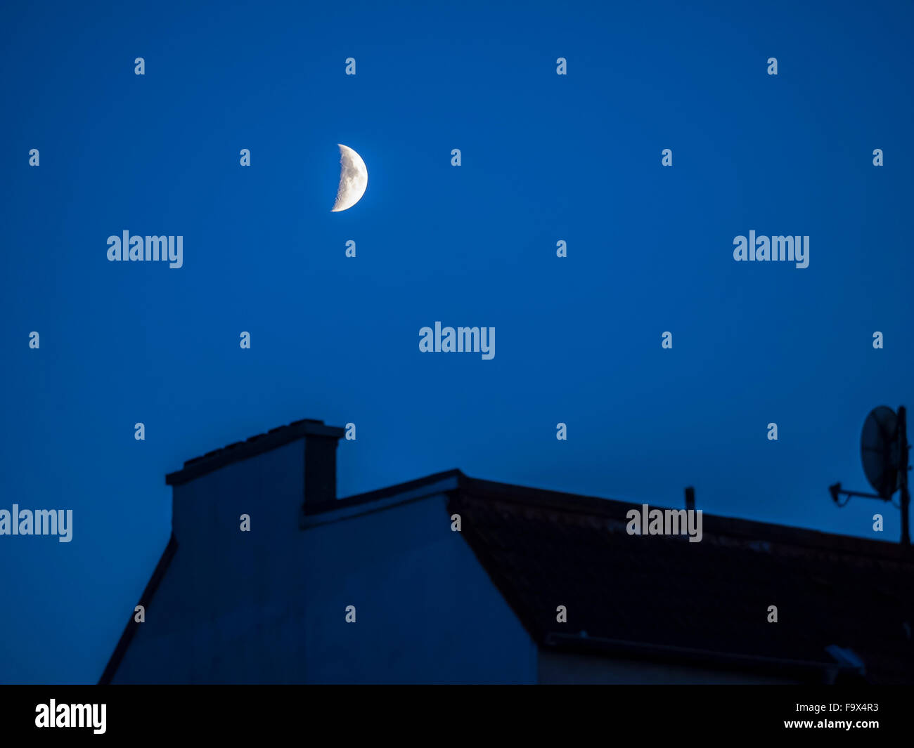 Deutschland, Hamburg, Halbmond über Dach zur blauen Stunde Stockfoto
