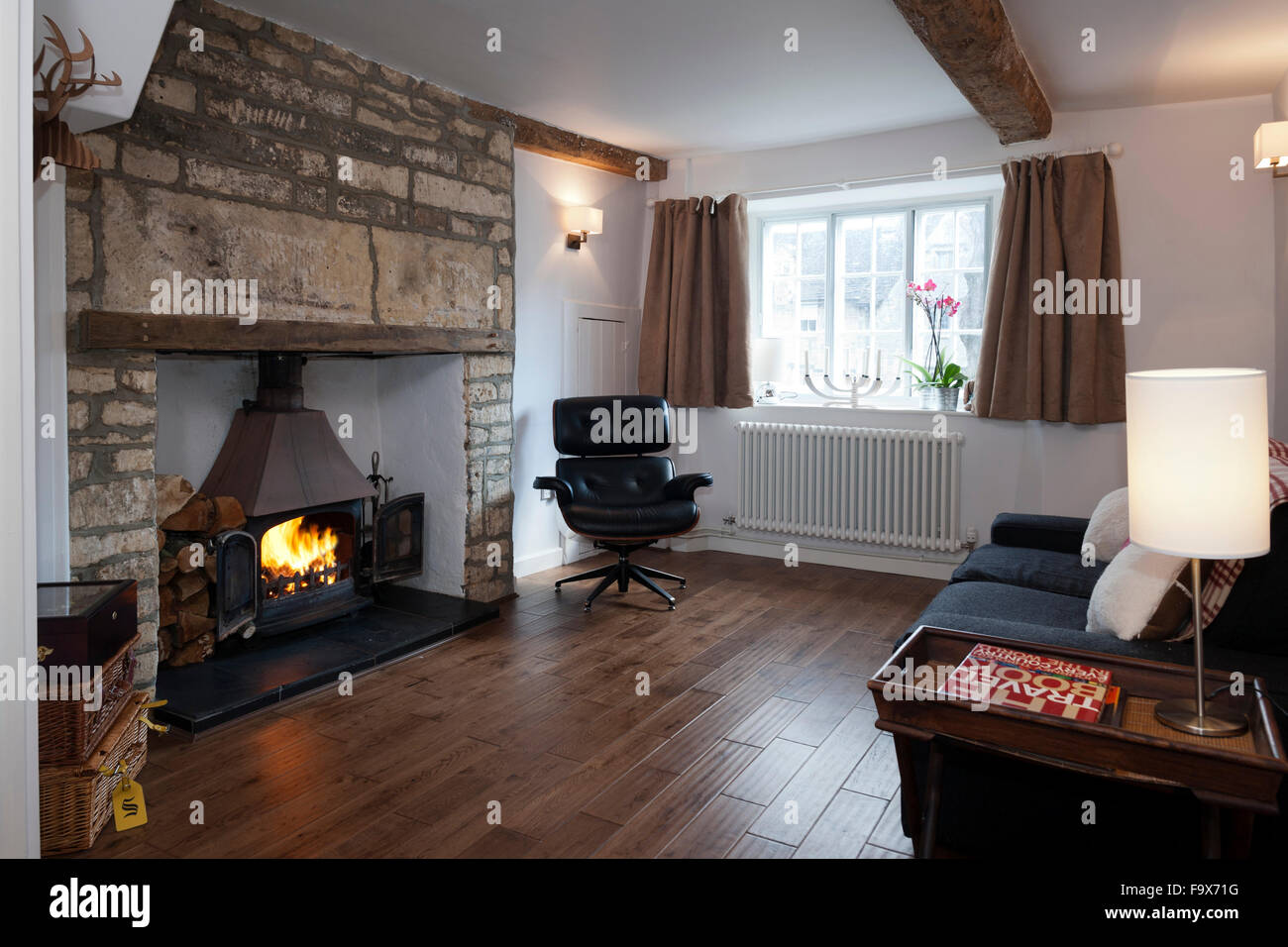 Ein Wohnzimmer mit einem Eames stil Stuhl in einer aktualisierten Old Stone Cottage. Stockfoto