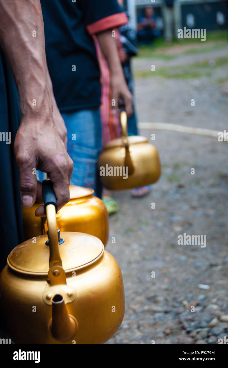 Schlange von Menschen mit goldenen Topf in der hand Stockfoto