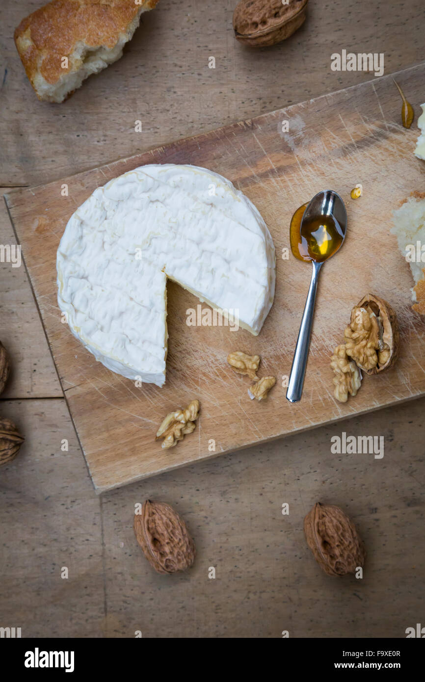 Camembert, Brot, Walnüssen und Honig auf Holz Stockfoto