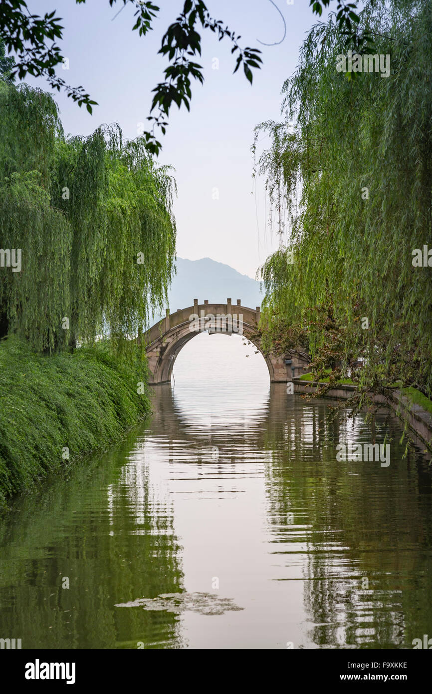 China, Zhejiang, Hangzhou, historische Brücke über einen kleinen Chanel am westlichen Seeufer Stockfoto