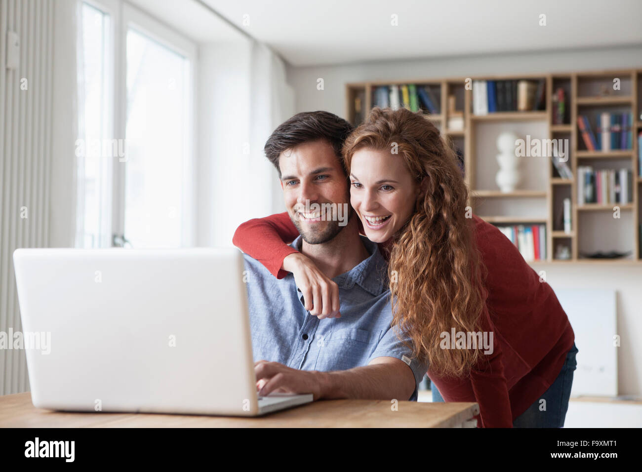 Glückliches Paar zu Hause mit Blick auf laptop Stockfoto