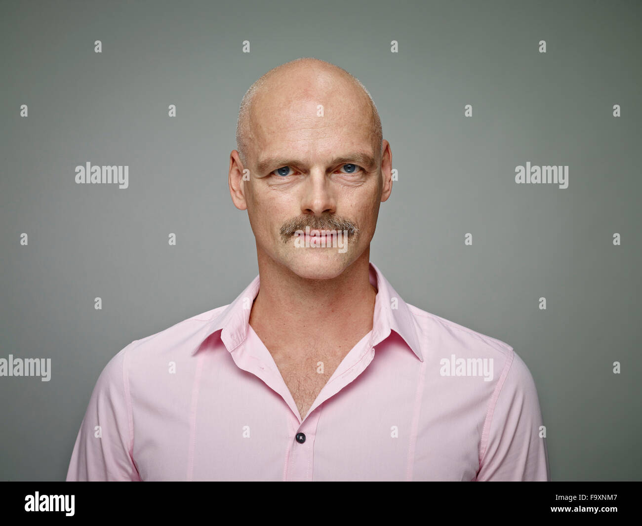 Porträt der glatzköpfige Mann mit dem Schnurrbart tragen rosa Hemd Stockfoto