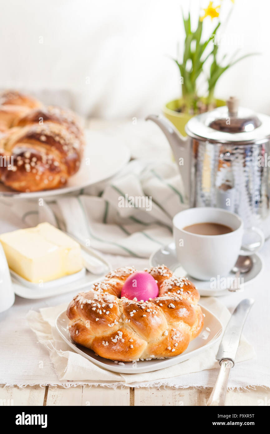 Geflochtene Osterbrot mit rosa Ei, Narzisse, Kaffee und butter Stockfoto